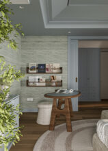 Góc làm việc trong phòng ngủ với cây xanh và kệ treo tạp chí. / Bedroom desk area detail with a green plant and wall-mounted magazine shelves.